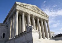 Supreme Court building with columns and statue in front.