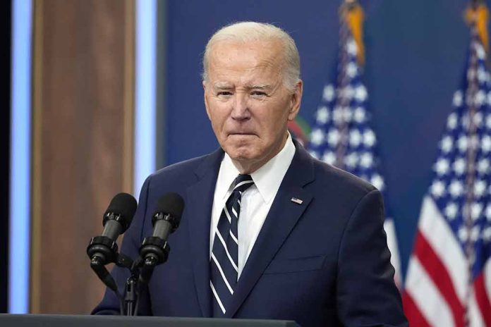 Man in suit speaking at podium with American flags.