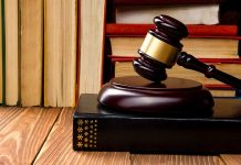 Gavel resting on books in front of bookshelf.