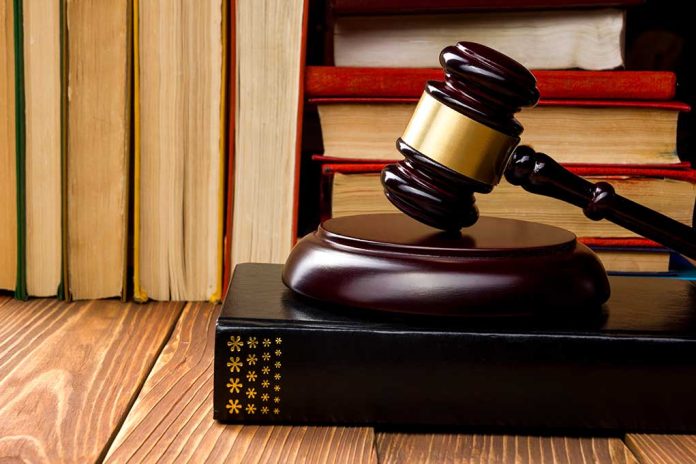 Gavel resting on books in front of bookshelf.