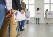 People standing in line holding voting papers.