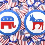 Republican elephant and Democratic donkey buttons, surrounded by flags.