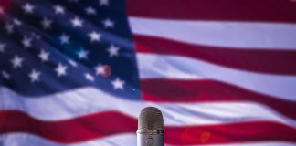 Microphone in front of blurred American flag.