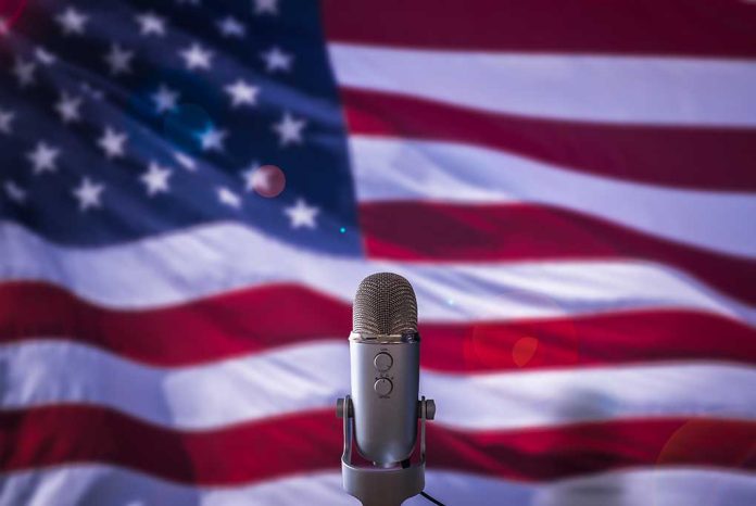 Microphone in front of blurred American flag.