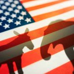 Donkey and elephant shadows on American flag.