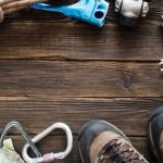 Hiking gear on wooden surface with boots visible