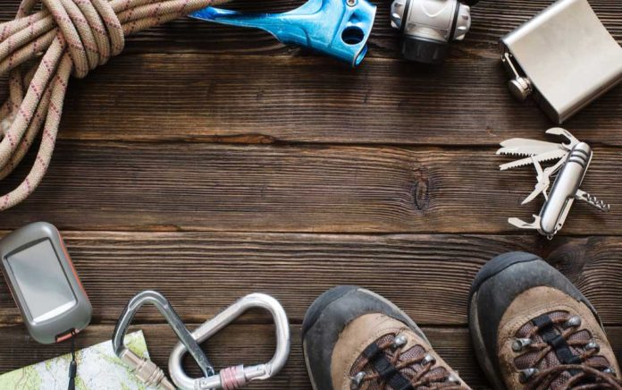 Hiking gear on wooden surface with boots visible