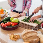 People preparing fresh vegetables in kitchen.