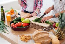 People preparing fresh vegetables in kitchen.