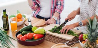 People preparing fresh vegetables in kitchen.