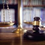 Gavel and scales of justice on desk.