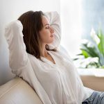 Woman relaxing on a couch near plants