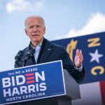 Man speaking at podium during outdoor event