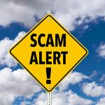 Yellow diamond sign saying scam alert warning