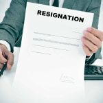 Person holding resignation letter at desk