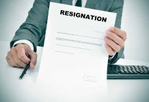 Person holding resignation letter at desk