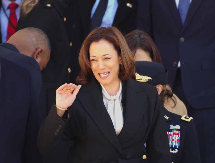 Smiling woman in black coat waves among people.