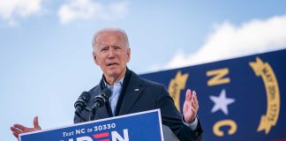 Man speaking at podium during outdoor event