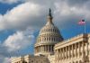 US Capitol Building with American flags and clouds