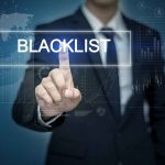 Man pressing virtual "blacklist" button.