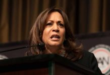 Woman speaking at podium with intense expression.