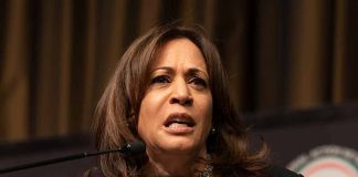 Woman speaking at podium with intense expression.