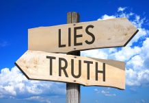 Signs pointing to "Lies" and "Truth" against sky.