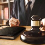 Gavel on table with glasses and notebook