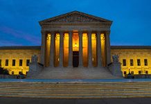 Illuminated courthouse building at dusk with columns