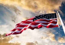 American flag waving against a dramatic cloudy sky