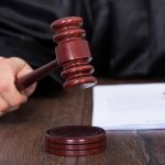 Judge holding a gavel in courtroom setting