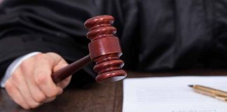 Judge holding a gavel in courtroom setting