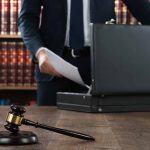 Gavel and person opening briefcase in law office