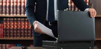 Gavel and person opening briefcase in law office
