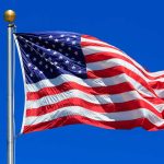 American flag waving against clear blue sky