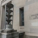 Department of Justice building with stone sculpture.