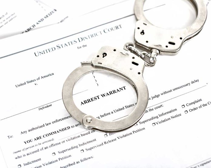 1316784506 featured image Handcuffs on top of an arrest warrant document.