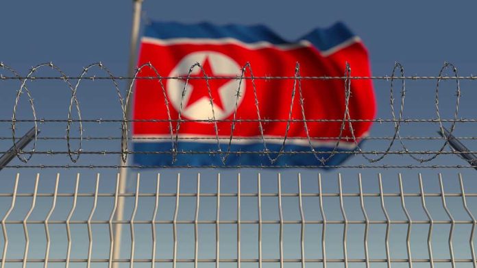 1336464401 featured image Barbed wire fence with North Korean flag behind