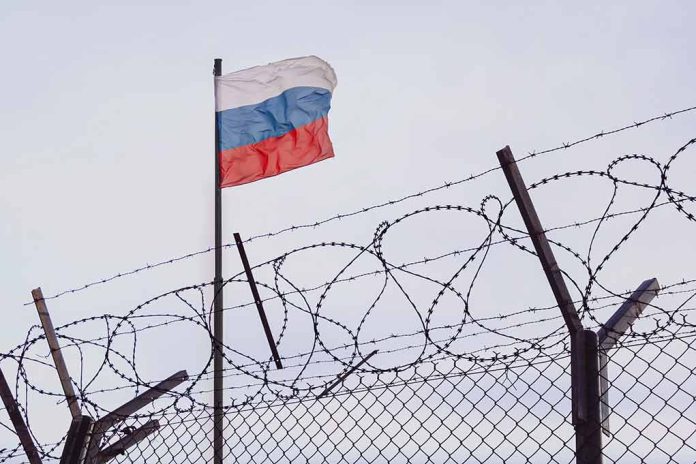 2148395873 featured image Barbed wire fence with Russian flag in background