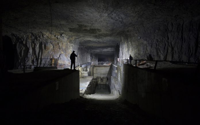 233319460 featured image Dimly lit underground industrial facility with shadowy figures