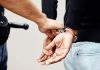 Person in handcuffs being arrested by police officer