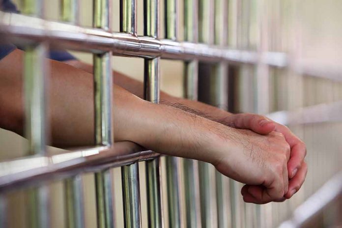 314390225 featured image Hands resting on prison bars