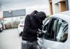 Person in black breaking into a car