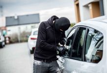 Person in black breaking into a car