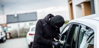 Person in black breaking into a car