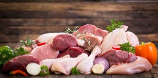 Assorted raw meat with vegetables on wooden table