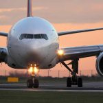 Airplane on runway during sunset lights on