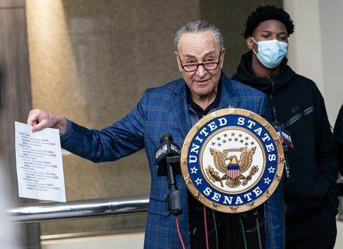 shutterstock_1932391145.jpg featured image Chuck Schumer holds document at United States Senate podium.