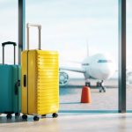 Two suitcases at airport window with airplane outside