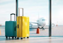 Two suitcases at airport window with airplane outside